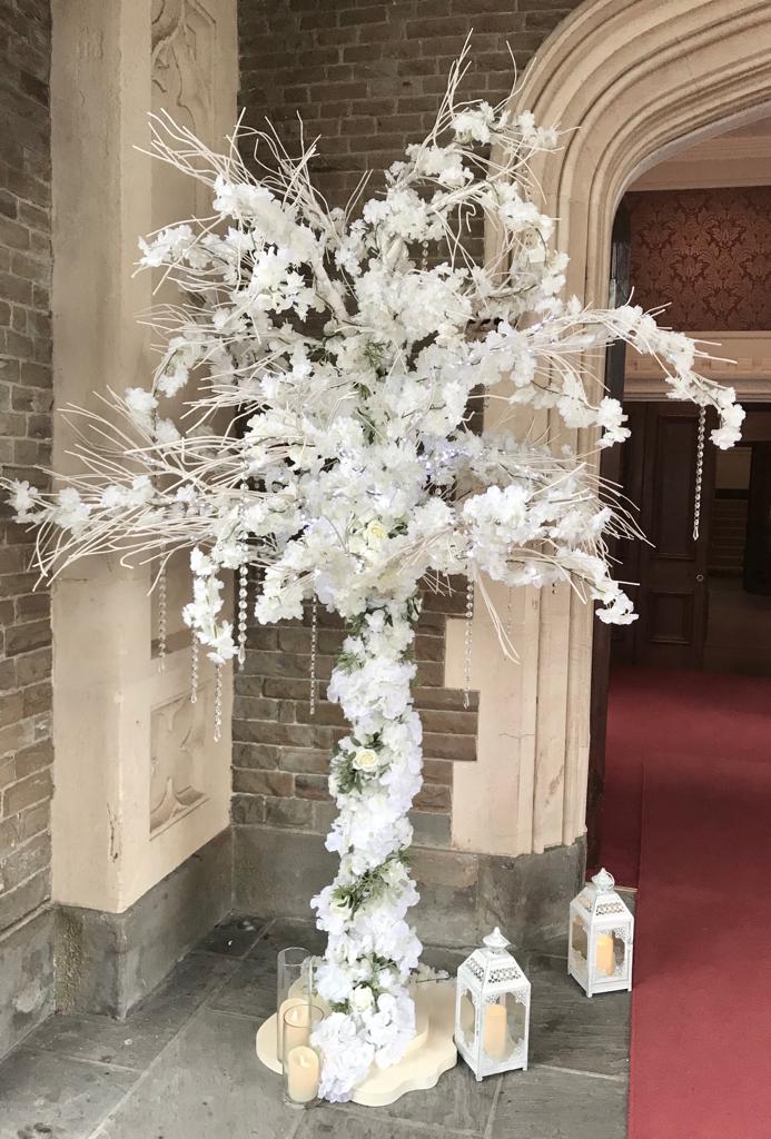 A tree with white flowers and candles hanging from it