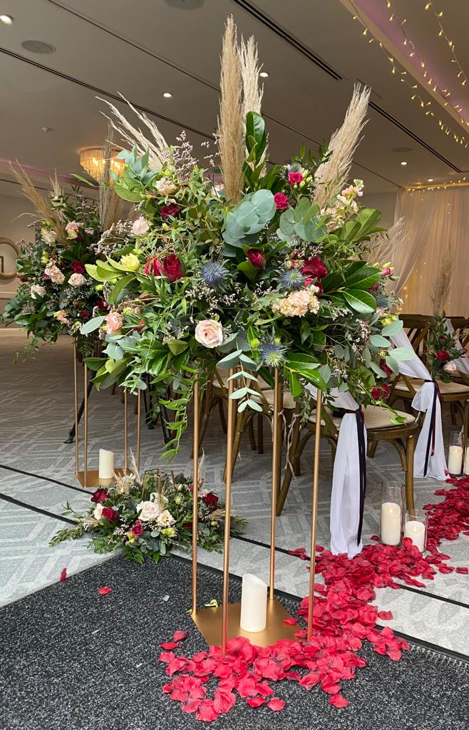 A wedding aisle with flowers and candles on the floor