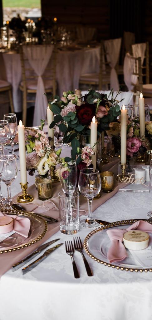 A table setting for a wedding with flowers and candles