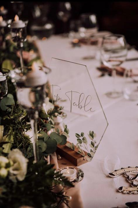 A table with flowers and candles and a table number on it .