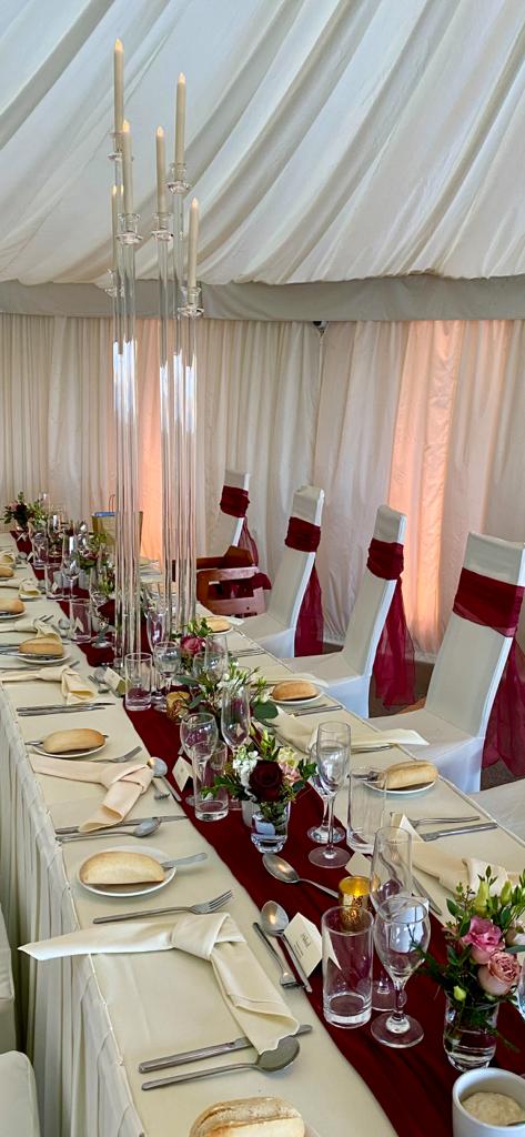 A long table set for a wedding reception with plates glasses and candles