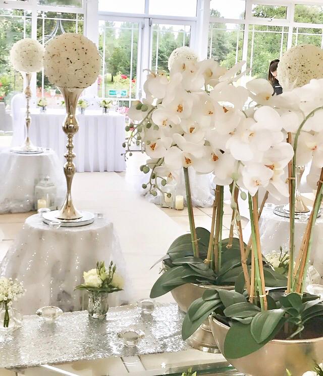 A room with a lot of white flowers on tables