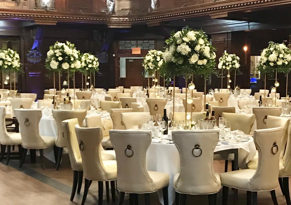 A large room with tables and chairs set up for a wedding
