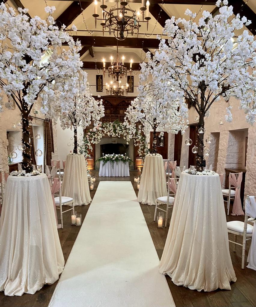 A wedding aisle with white tables and chairs
