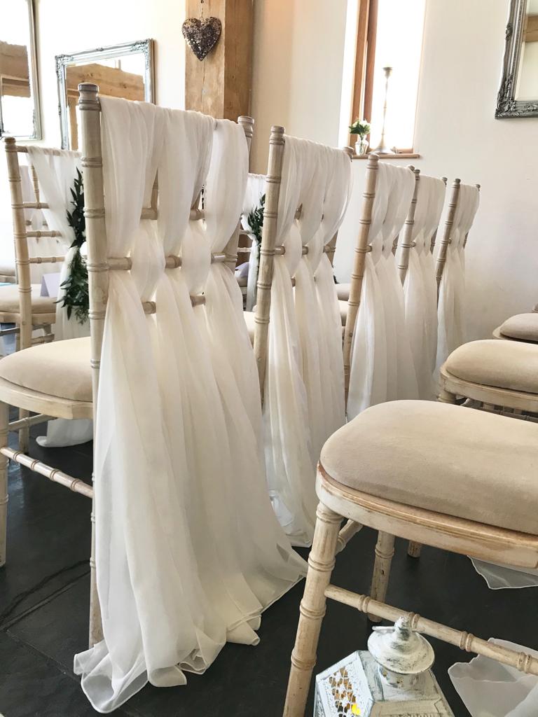 A row of chairs are decorated with white cloths
