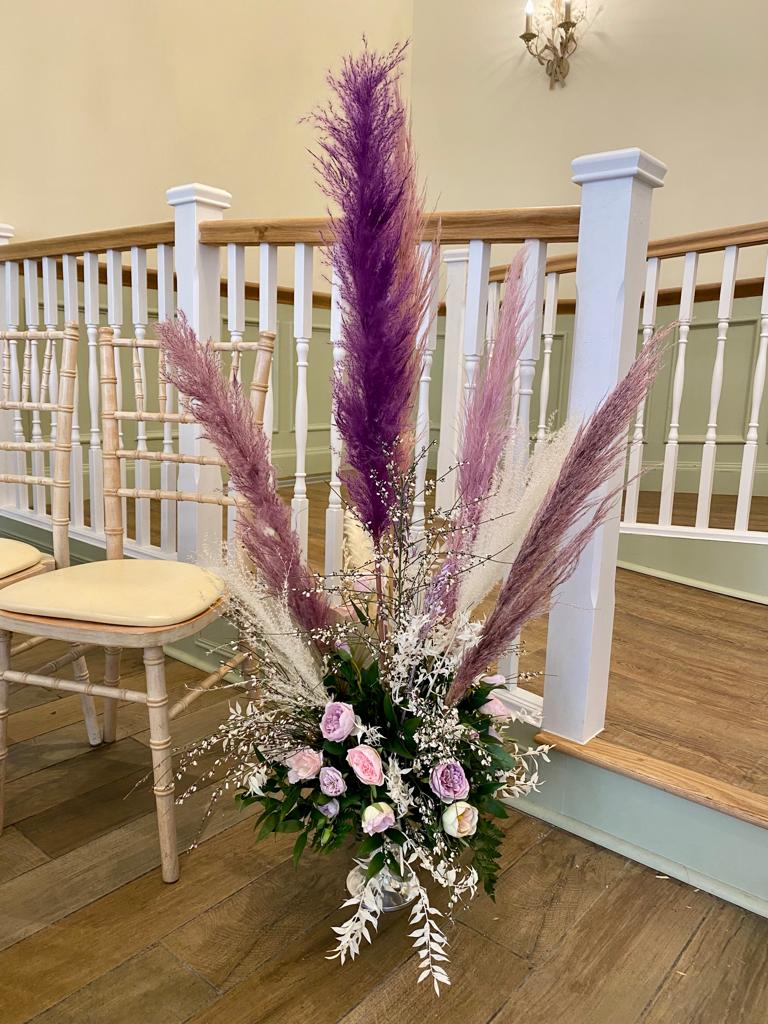 A vase filled with purple and white flowers sits on a staircase