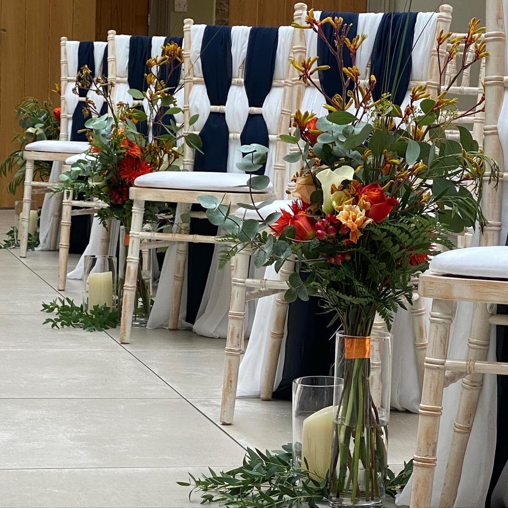A row of chairs with flowers and candles on them
