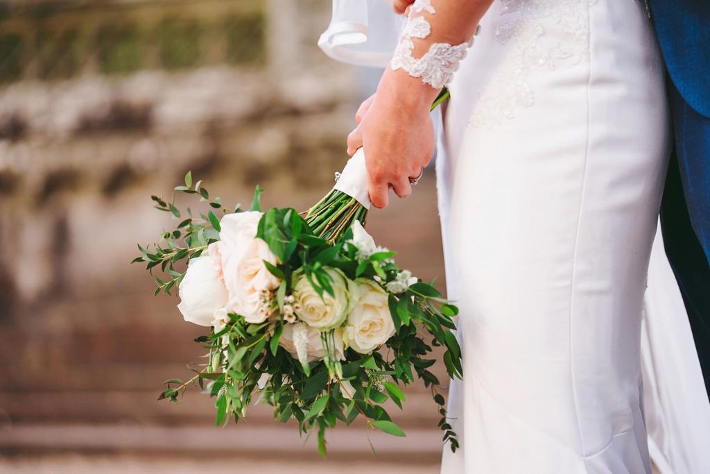 a bride holds a bouquet of flowers in her hand
