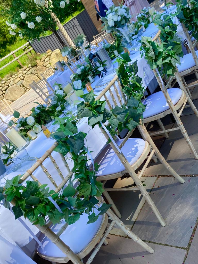 a row of chairs with ivy hanging from the backs