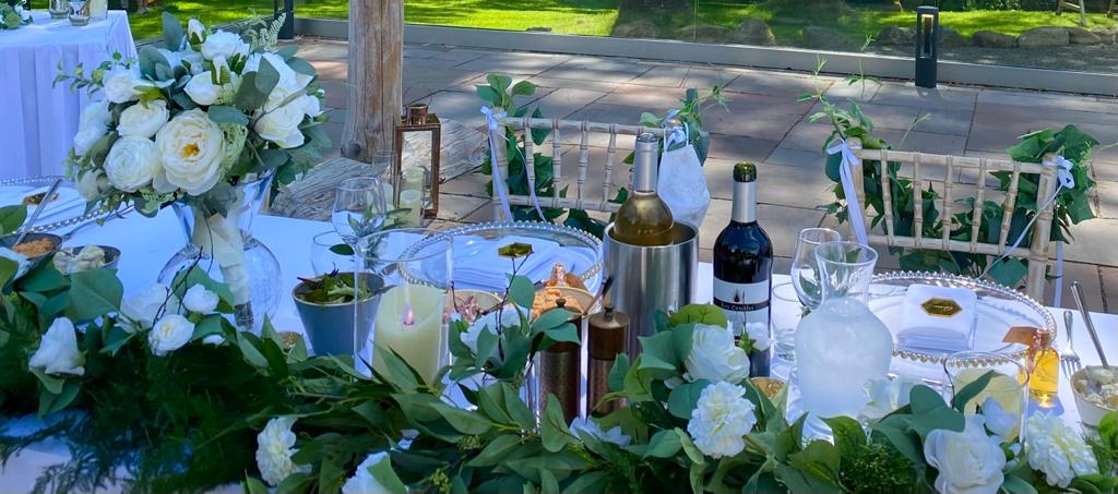 a bottle of wine sits on a table surrounded by flowers
