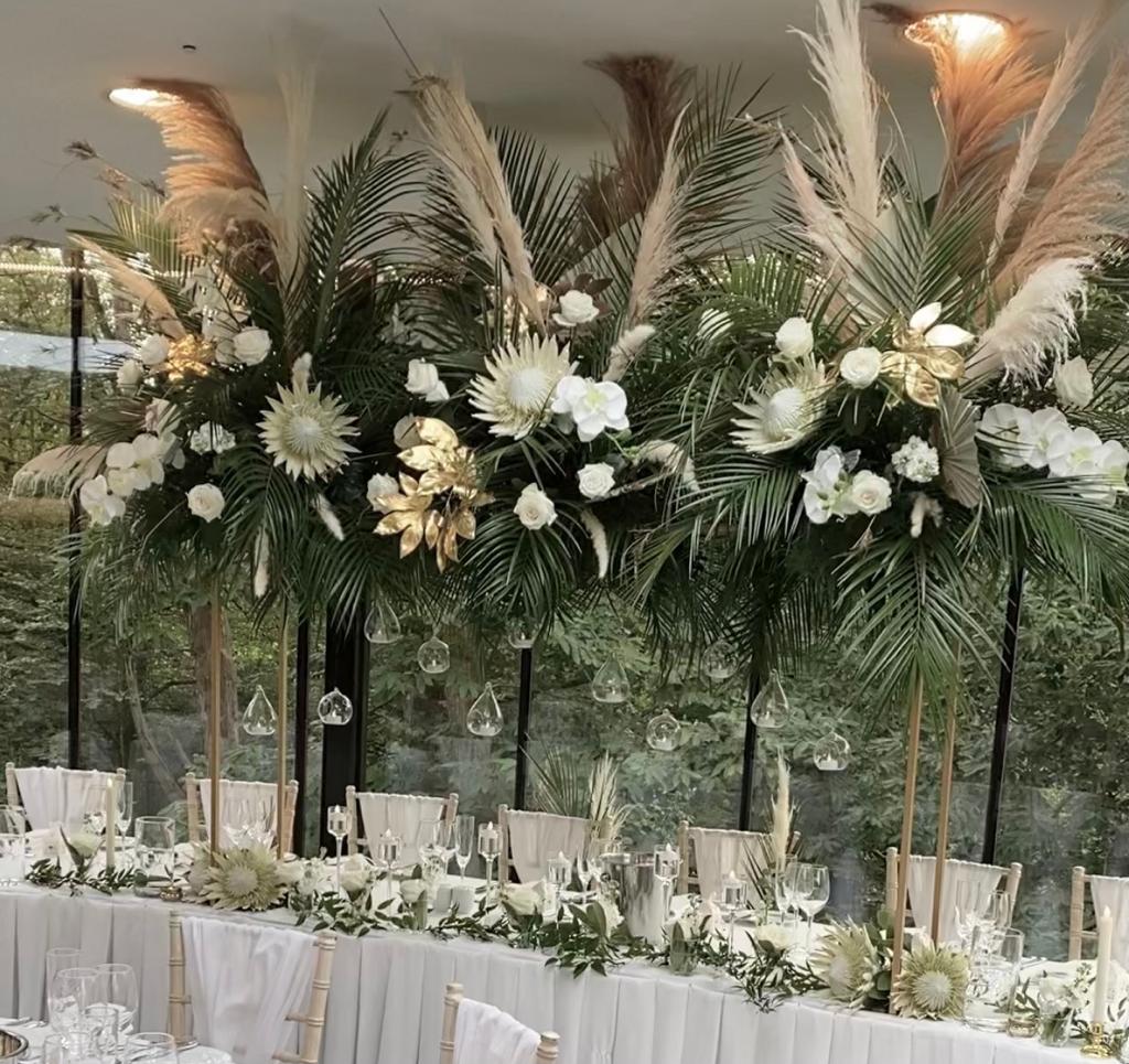 a long table is decorated with white flowers and greenery