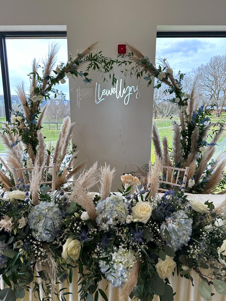 a table with flowers and a sign that says lewellyn on it