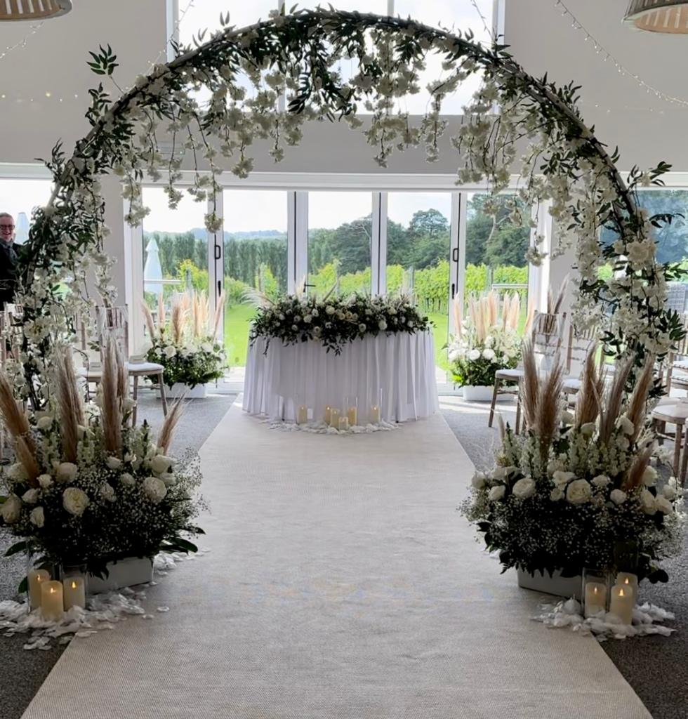 a wedding aisle with flowers and candles on the floor