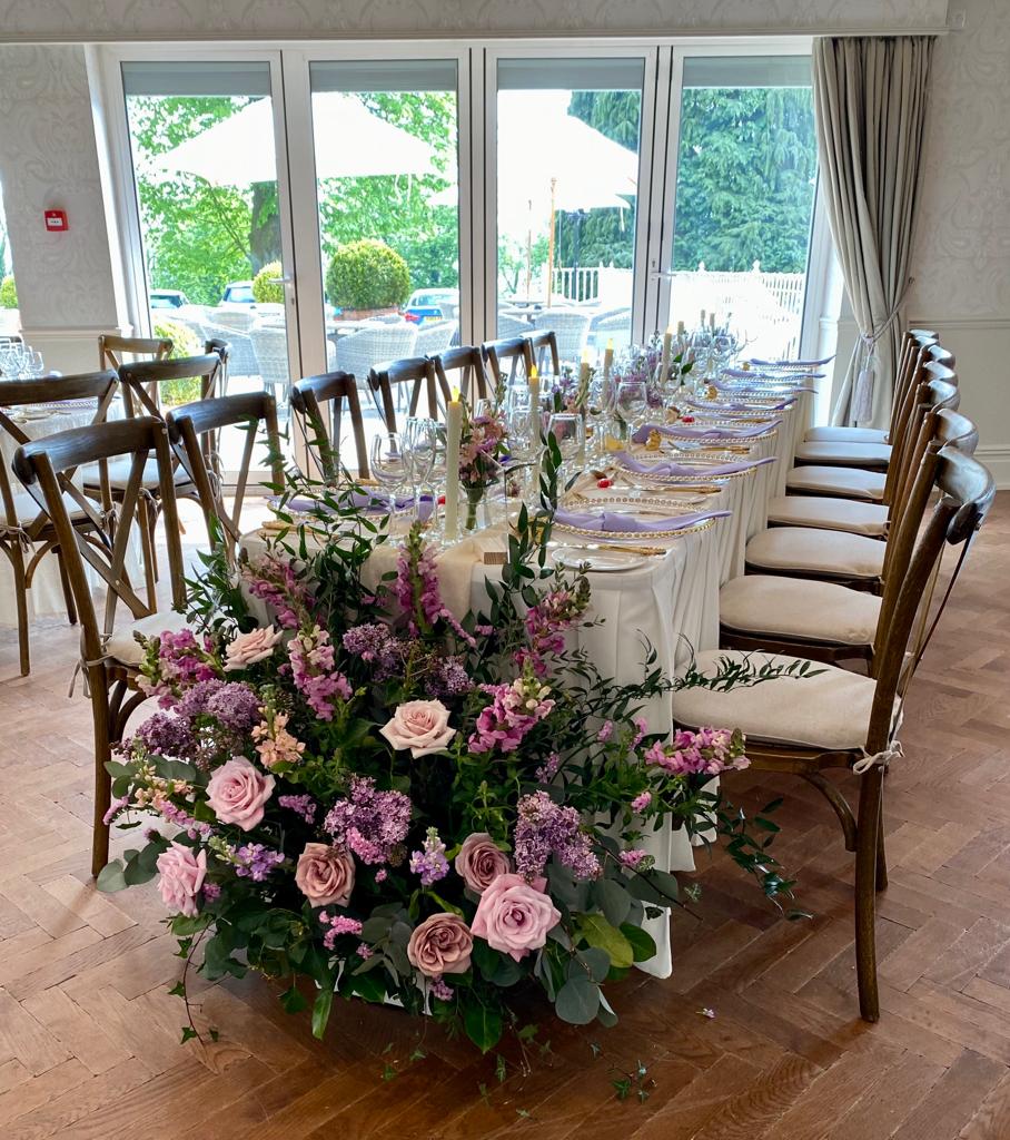 a long table with purple flowers in front of it
