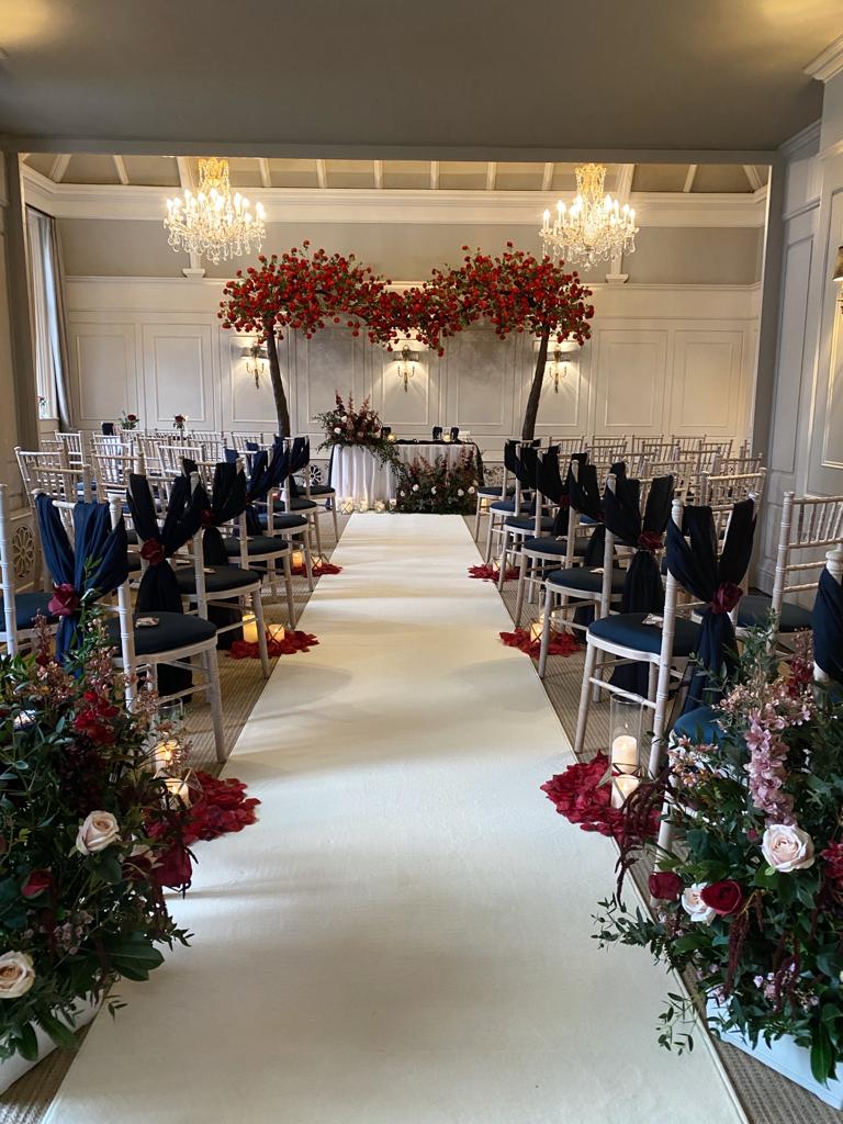 the aisle of a wedding ceremony is decorated with red flowers and candles