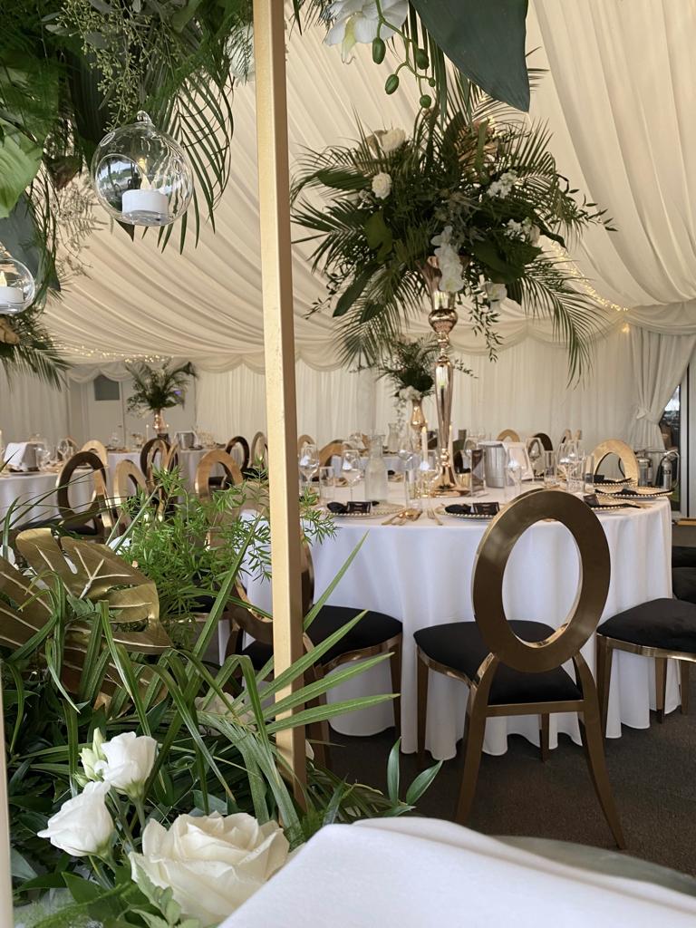 a tent is set up for a wedding reception with tables and chairs