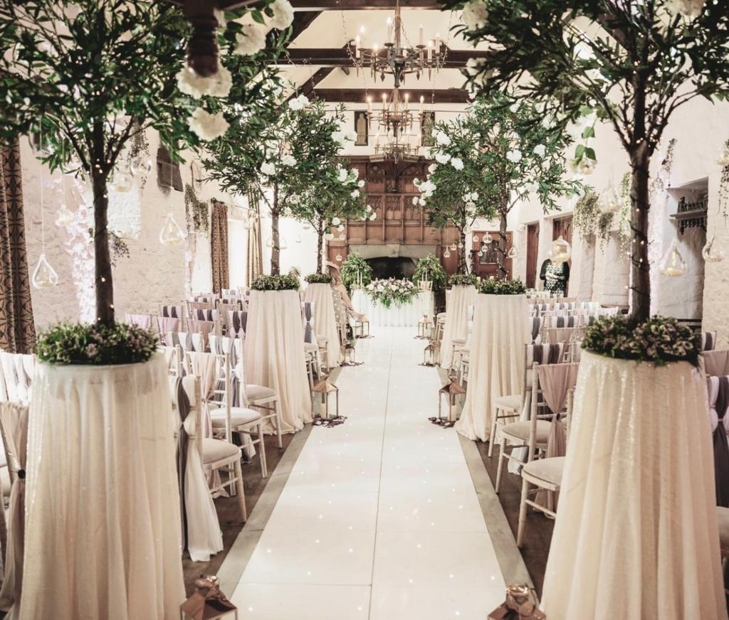the aisle of a wedding ceremony is lined with white tables and chairs