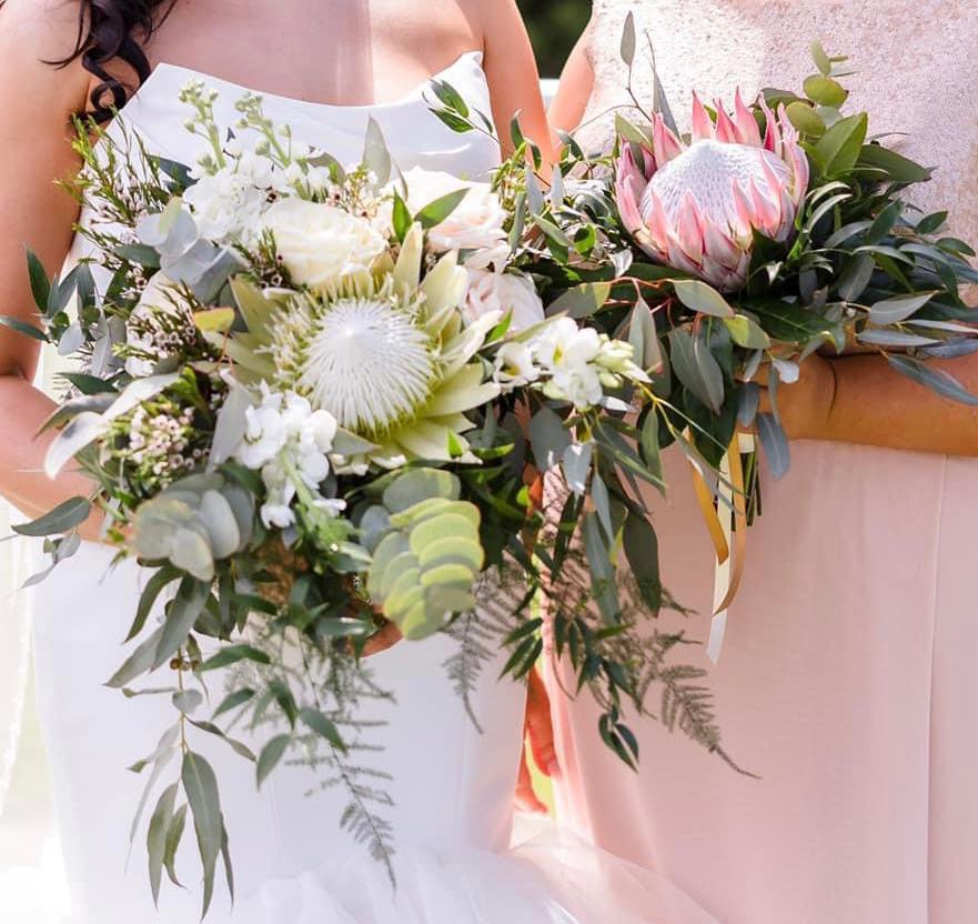 a bride and her bridesmaid are holding bouquets of flowers
