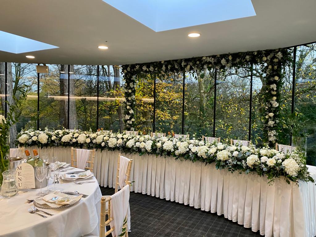 a long table with white flowers and a sign that says mr and mrs