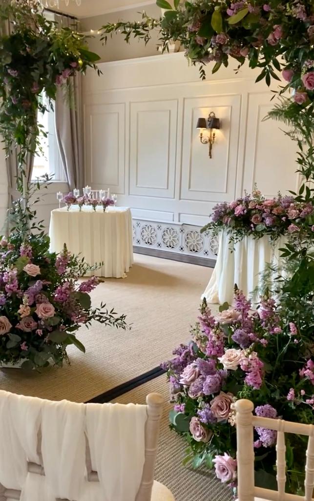 a room with purple and pink flowers and a table