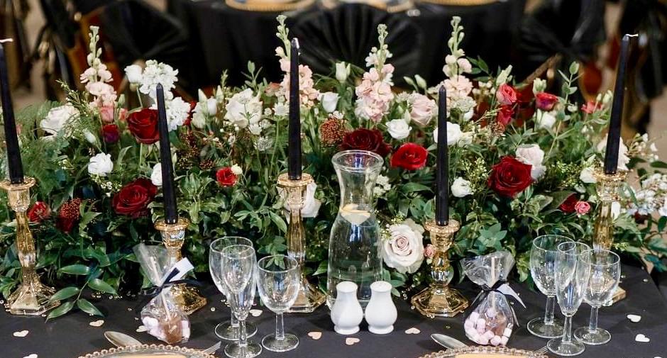 a table set for a wedding reception with flowers and candles .